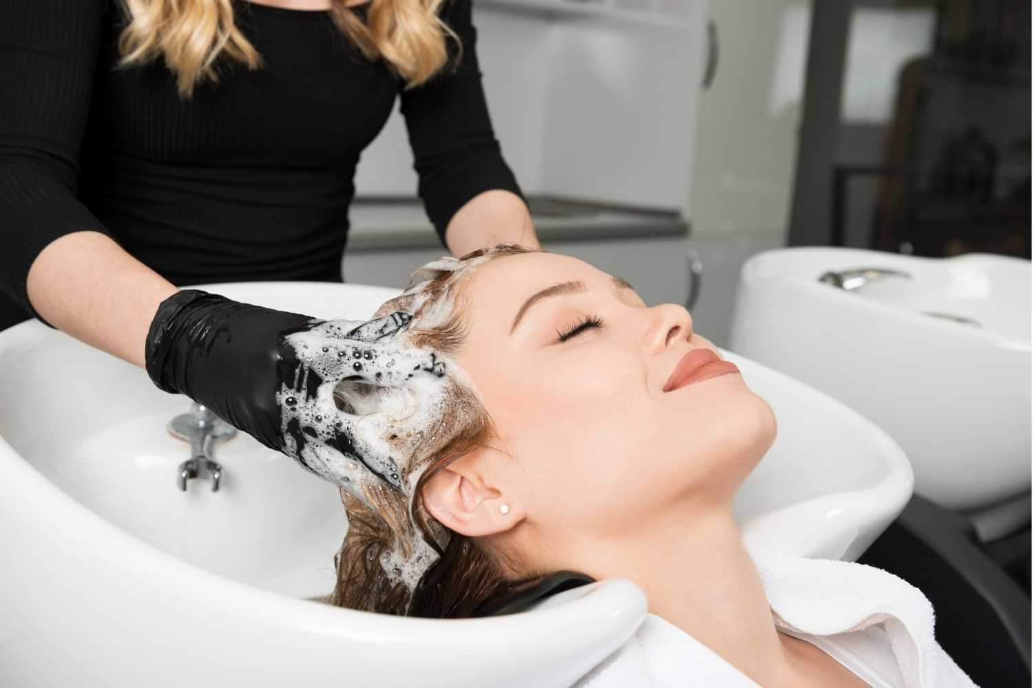 A woman enjoys a relaxing hair wash at a modern salon.